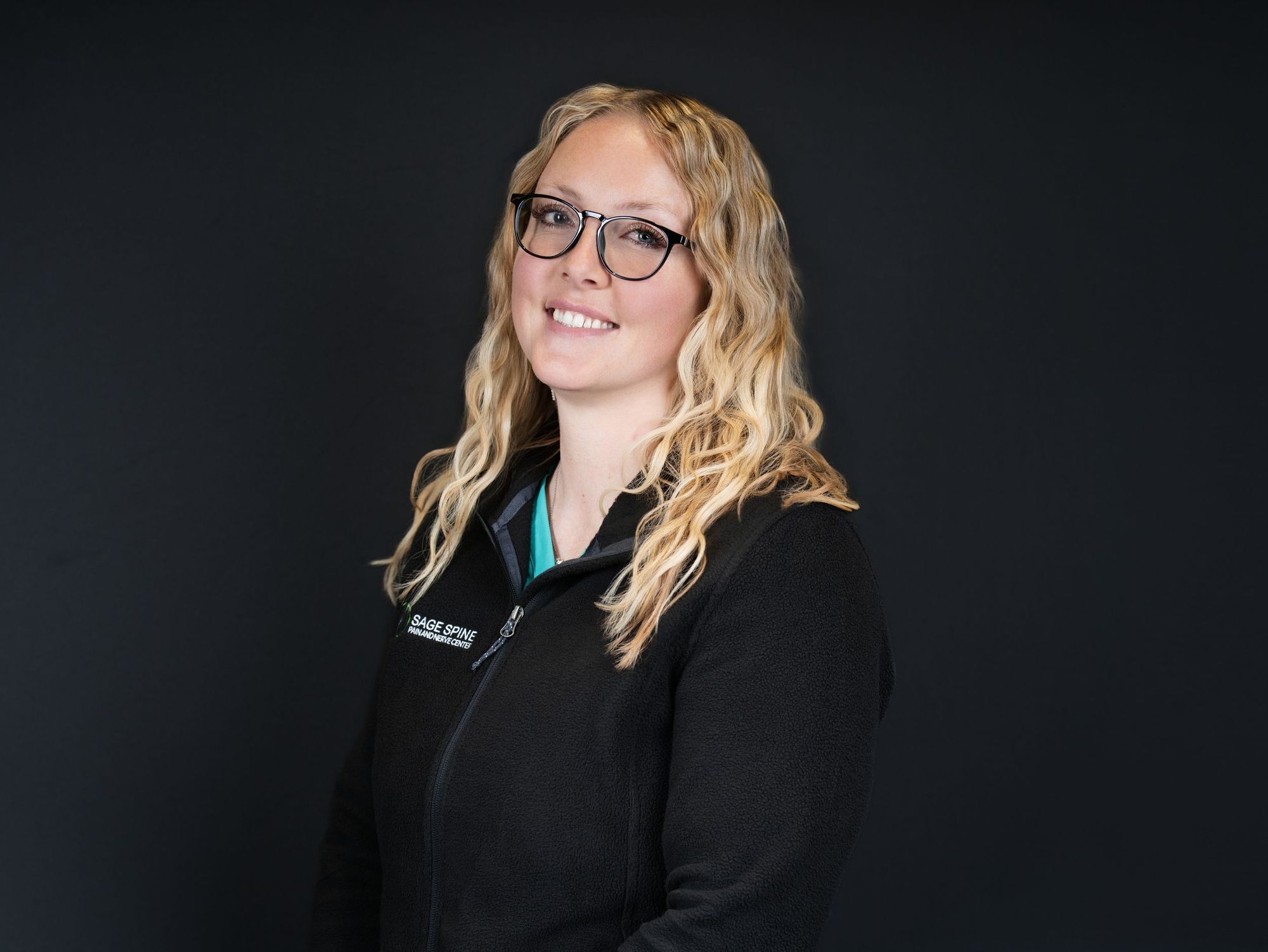 Professional headshot of a woman on a black backdrop